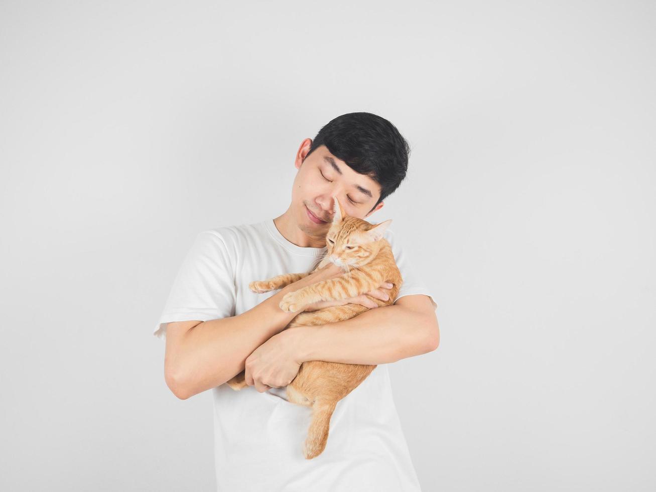 Asian man carry and hugging lovely cat orange color on white isolated background photo