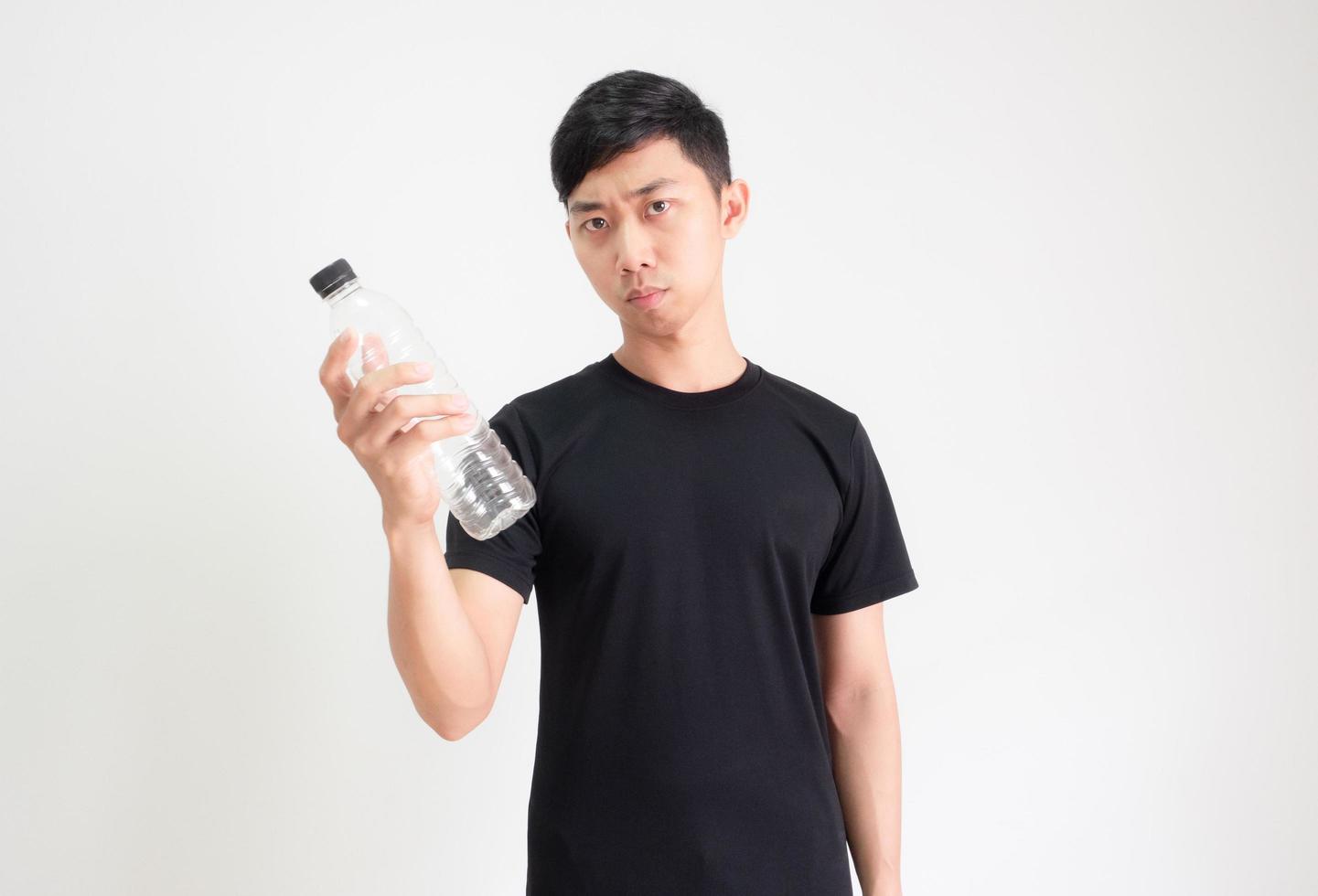 Asian man black shirt holding plastic bottle in hand and look at camera confused face on white isolated background photo