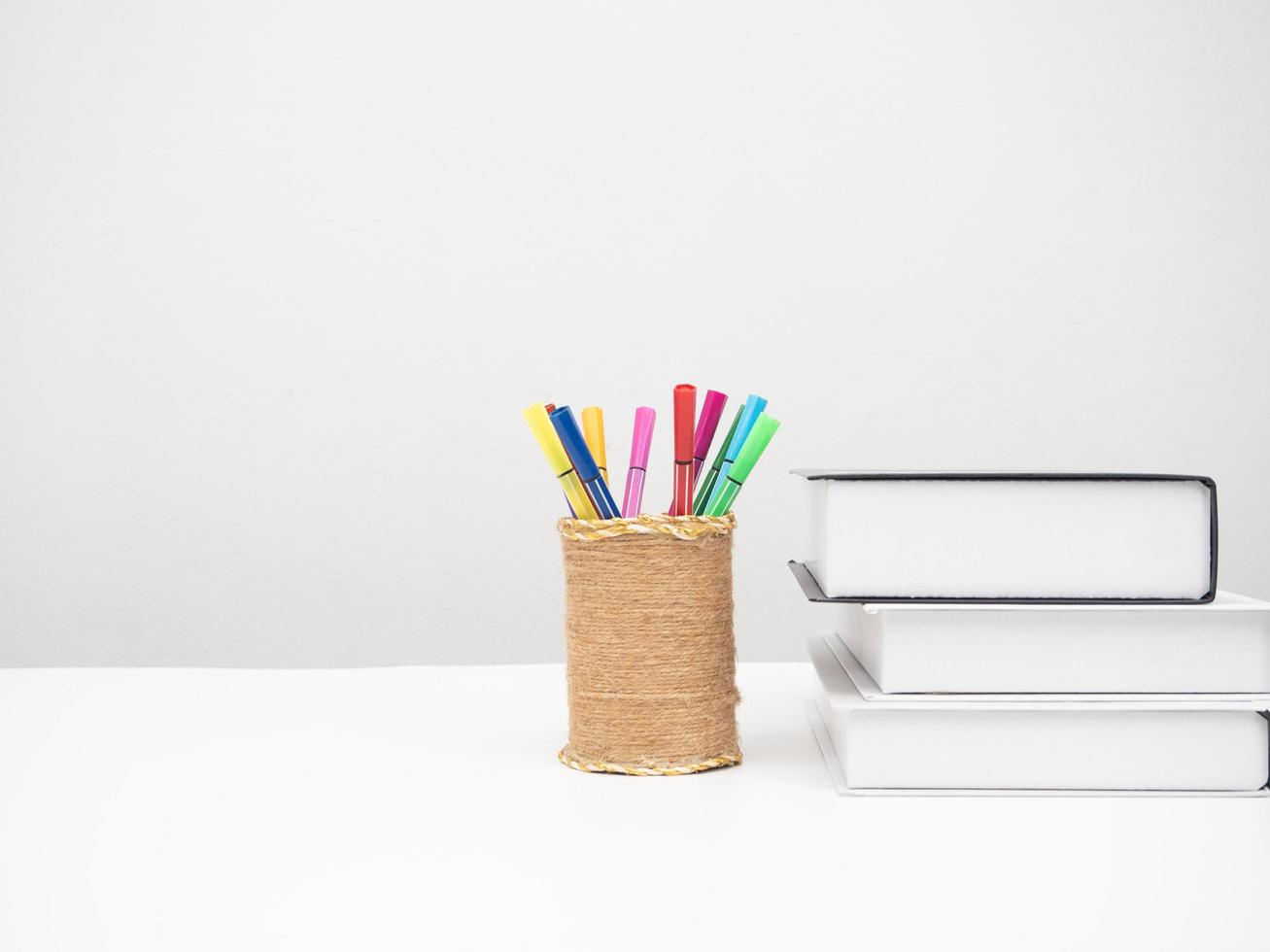 Books with pencil color box on the desk white background copy space photo