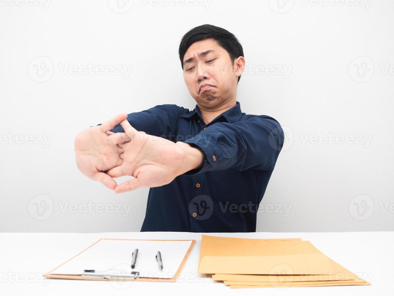 Businessman sitting at his workplace stretch oneself feeling lazy to working photo
