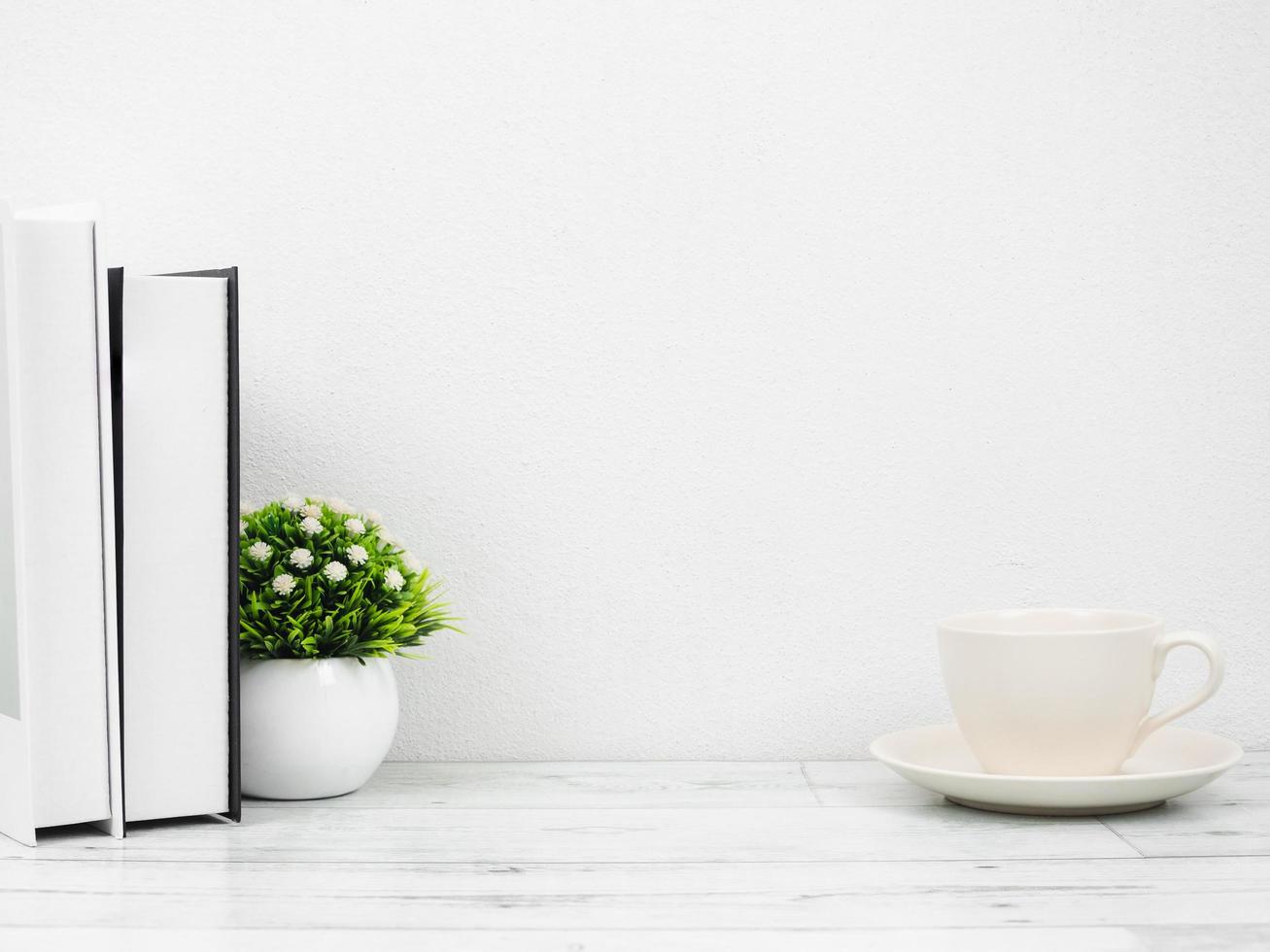 Books and small vase on white wood table minimal style copy space white wall,Workspace at home photo