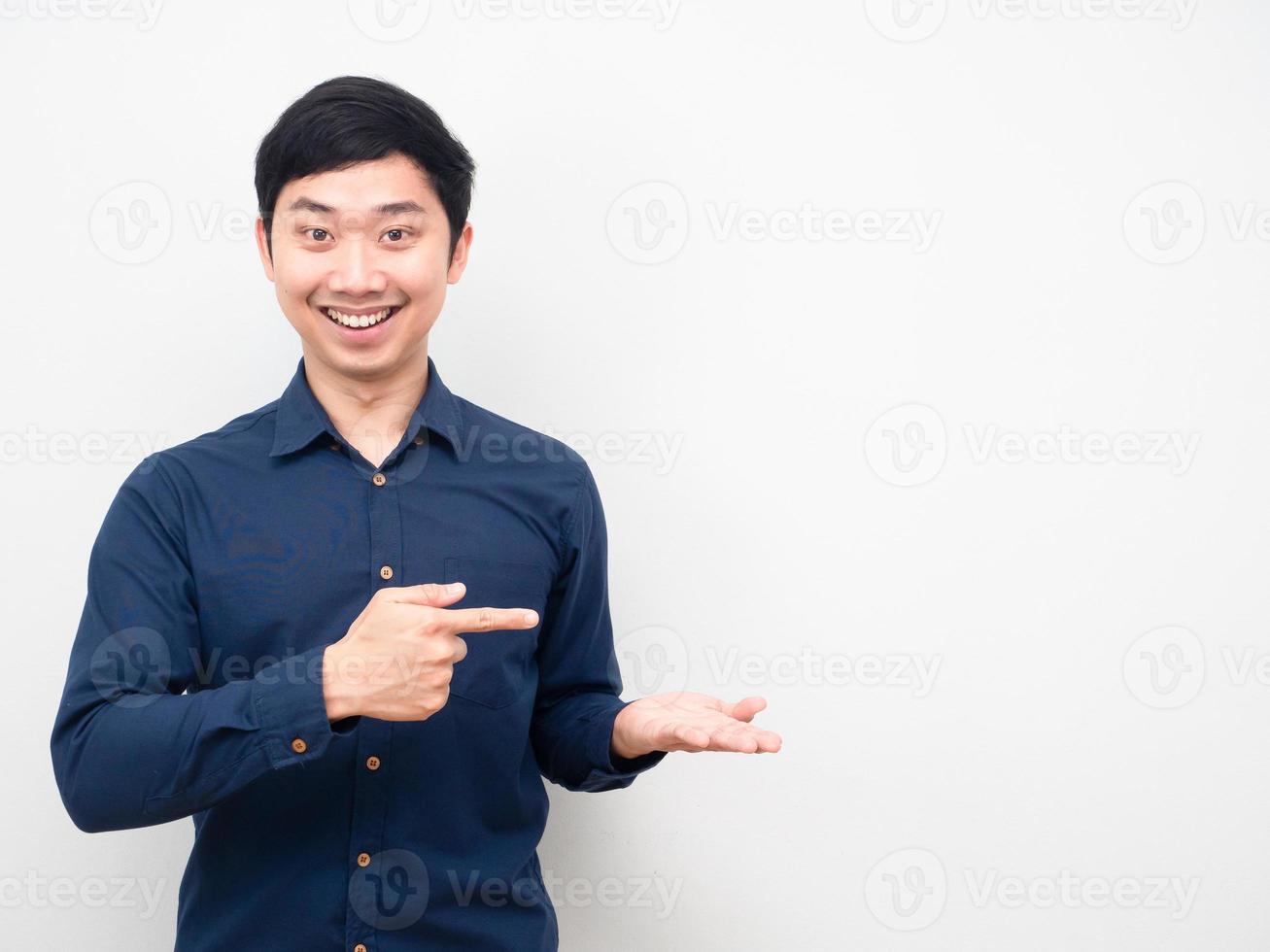 Asian man happy emotion show empty hand up and point finger copy space photo