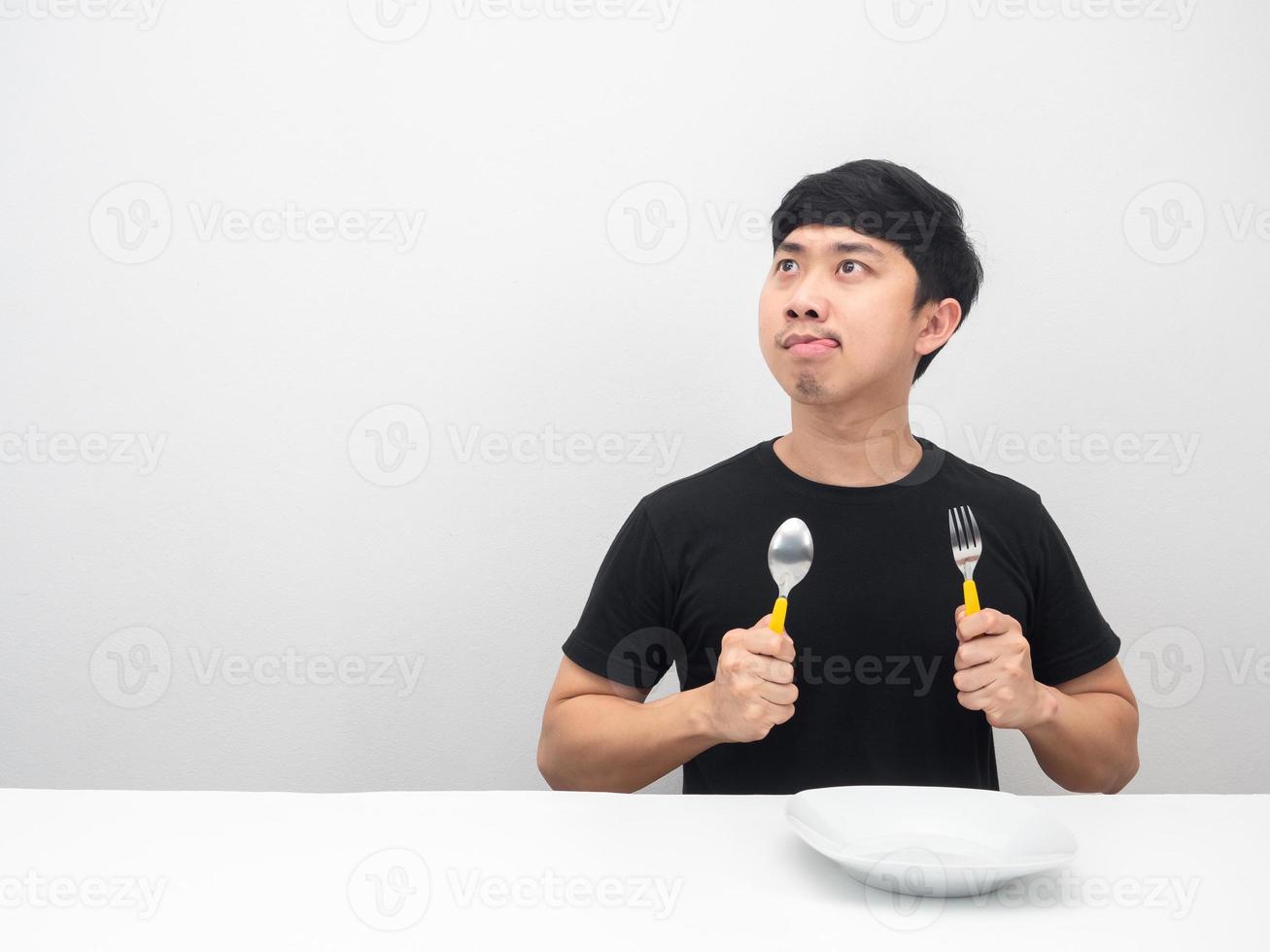 hombre sosteniendo cubiertos sintiendo hambre y mirando el espacio de copia foto