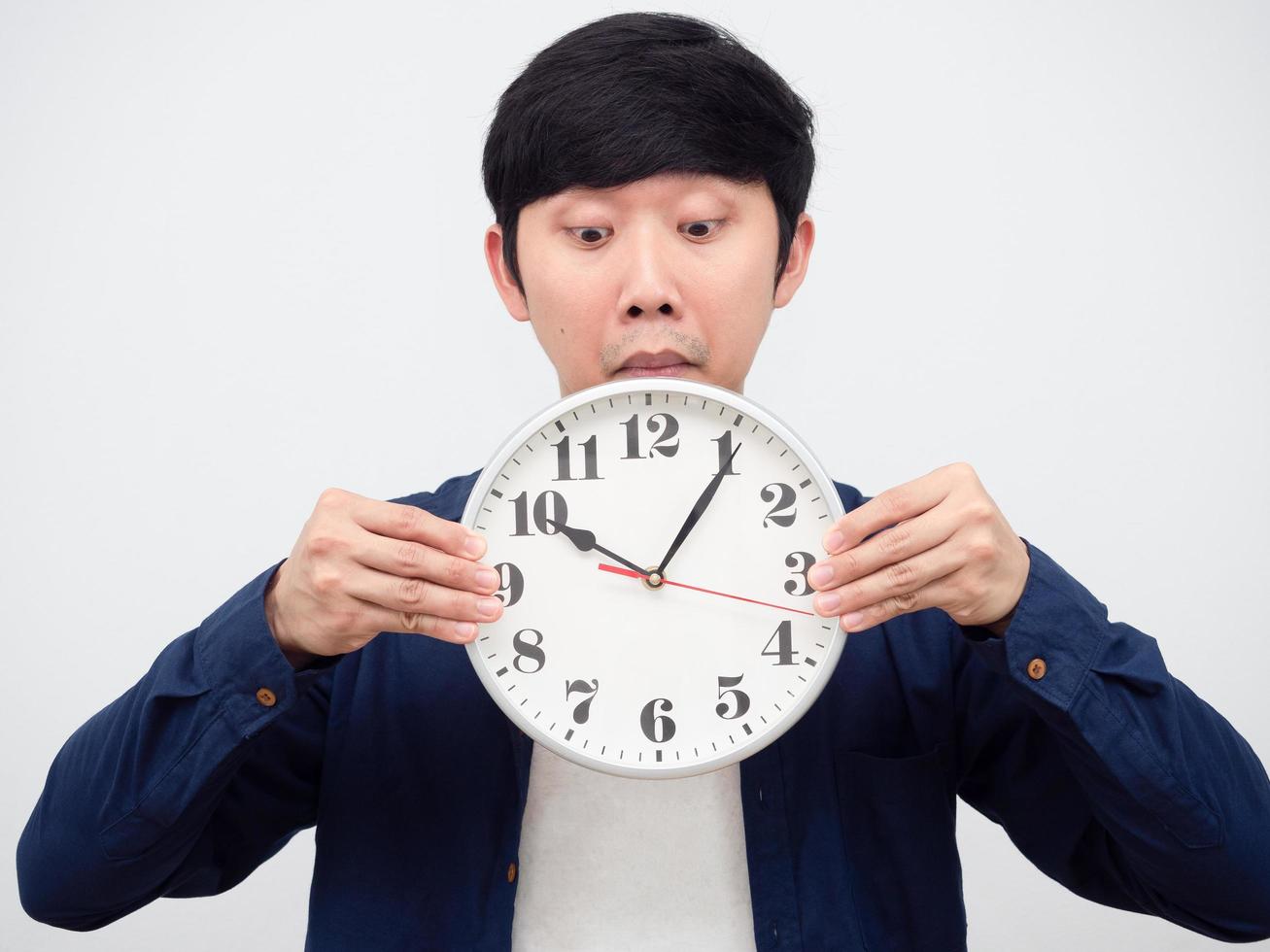 Asian man excited to looking at clock in his hand portrait,Late concept photo