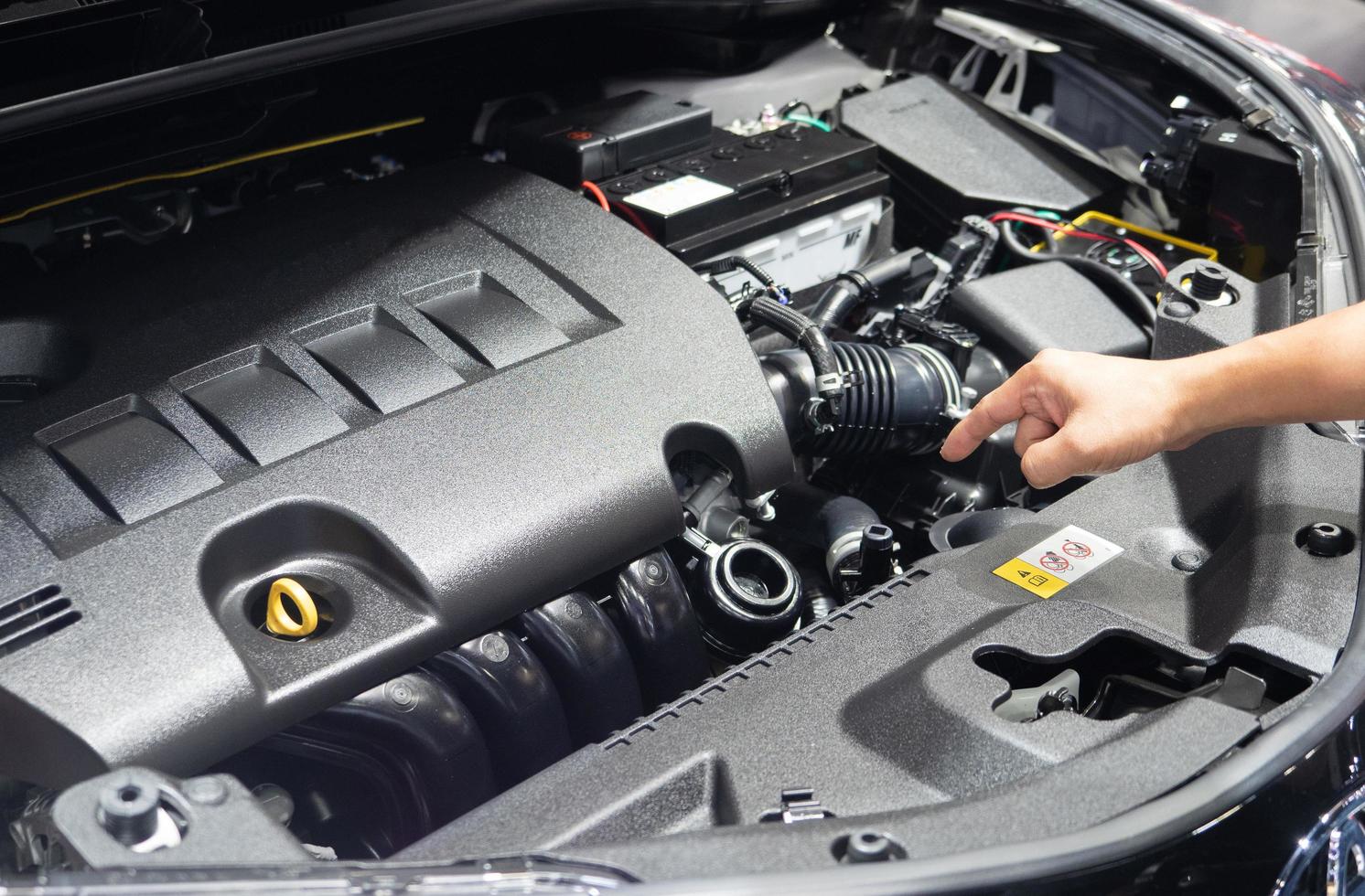Hand point finger at engine interior of new car photo