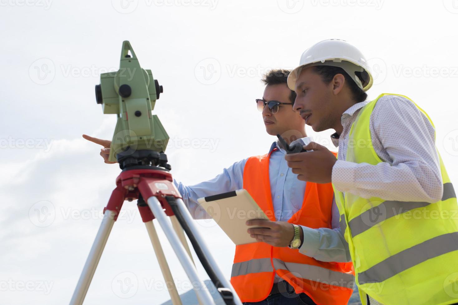 Surveyor engineer is measuring level on construction site. Surveyors ensure precise measurements before undertaking large construction projects. photo
