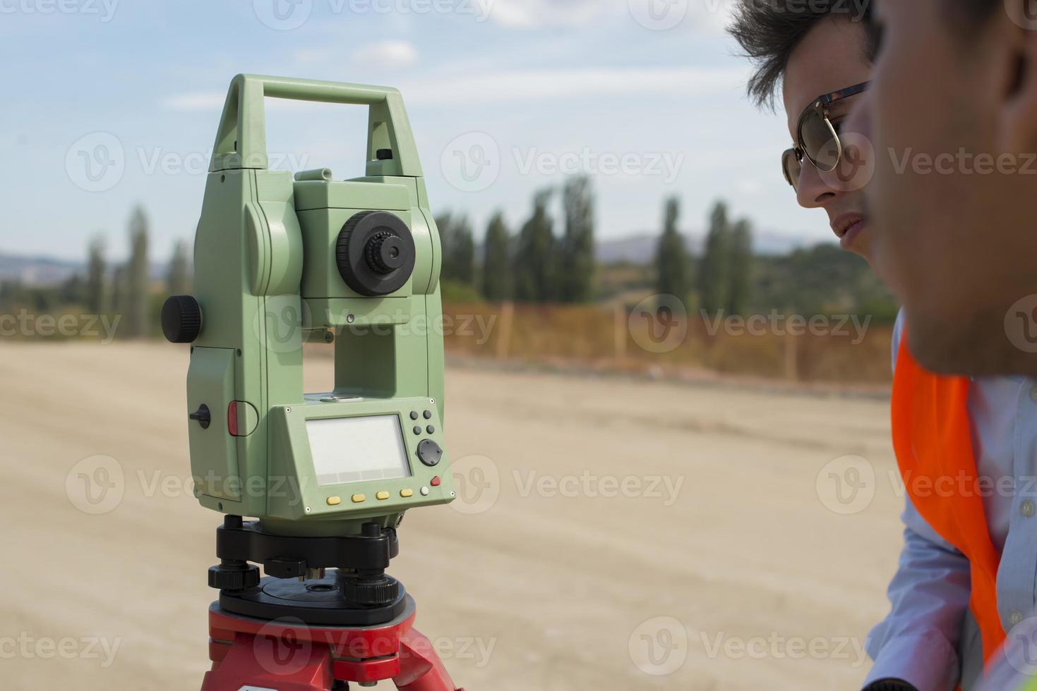 Surveyor engineer is measuring level on construction site. Surveyors ensure precise measurements before undertaking large construction projects. photo