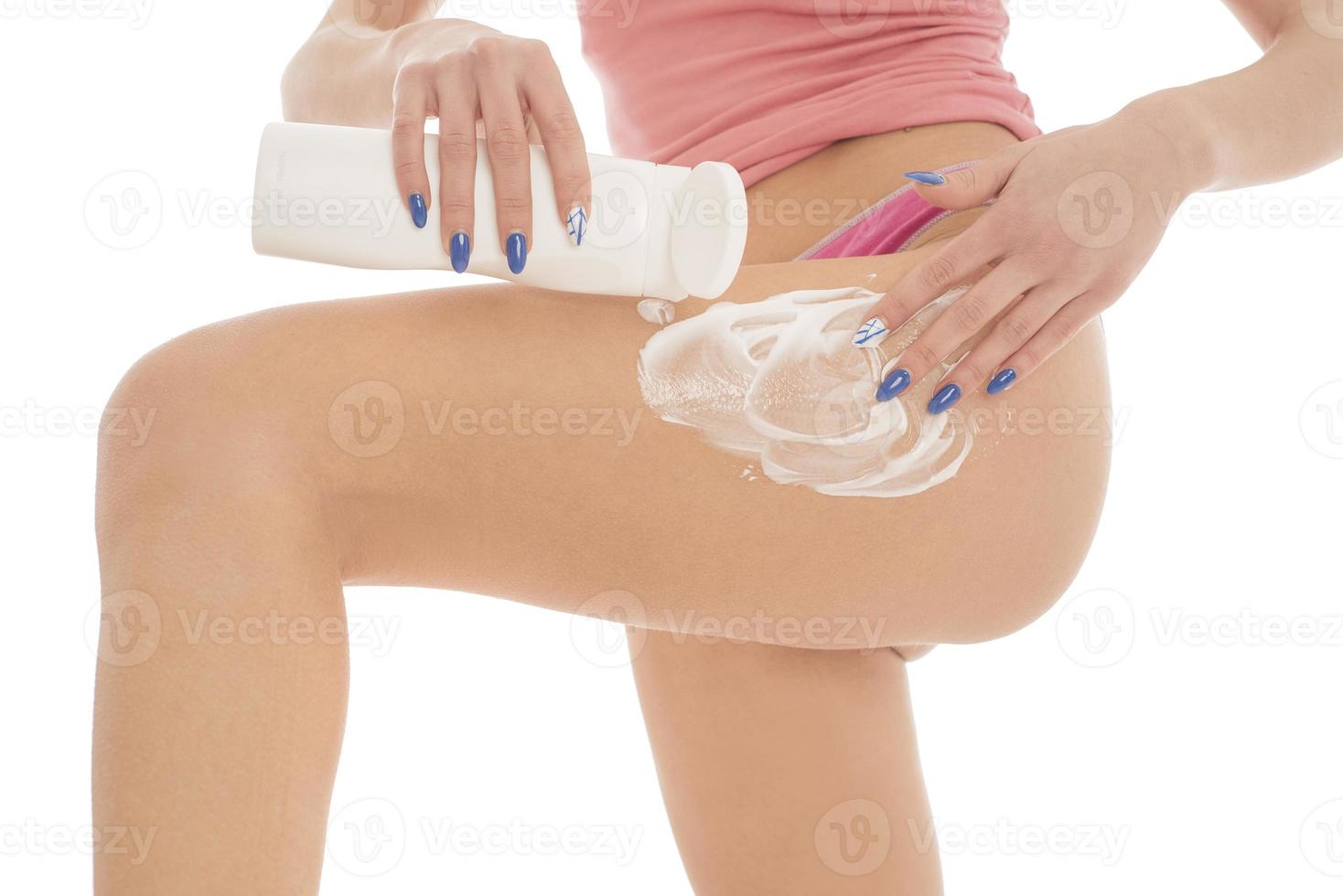 cuidado del cuerpo. mujer aplicando crema en las piernas. mujer aplicando crema anticelulítica foto