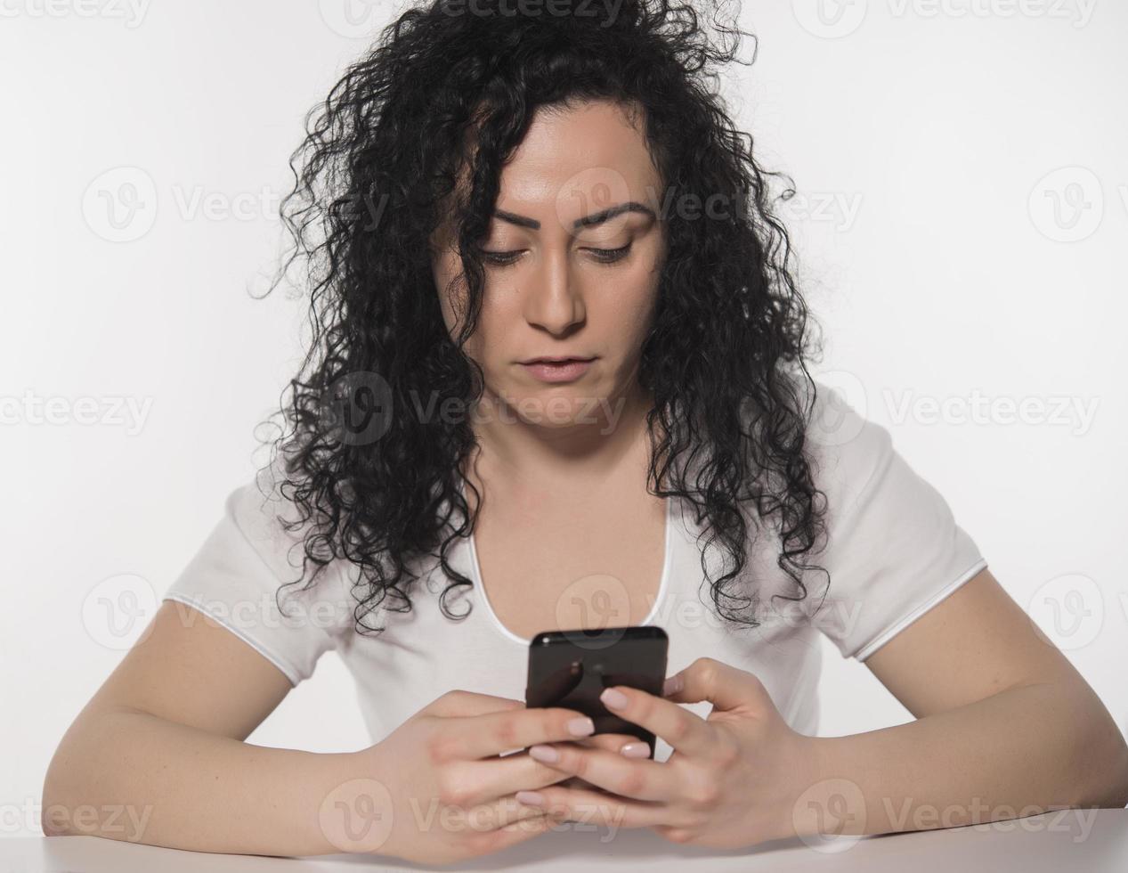 Portrait of a happy woman using mobile phone isolated over white background photo