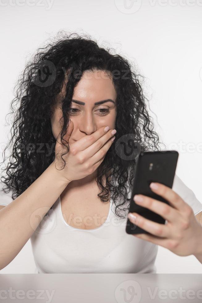 Portrait of a happy woman using mobile phone isolated over white background photo