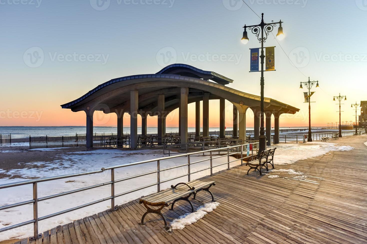 Coney Island Boardwalk with Parachute Jump in the background in Coney Island, NY. The boardwalk was built in 1923 and stretches for 2.51 miles photo