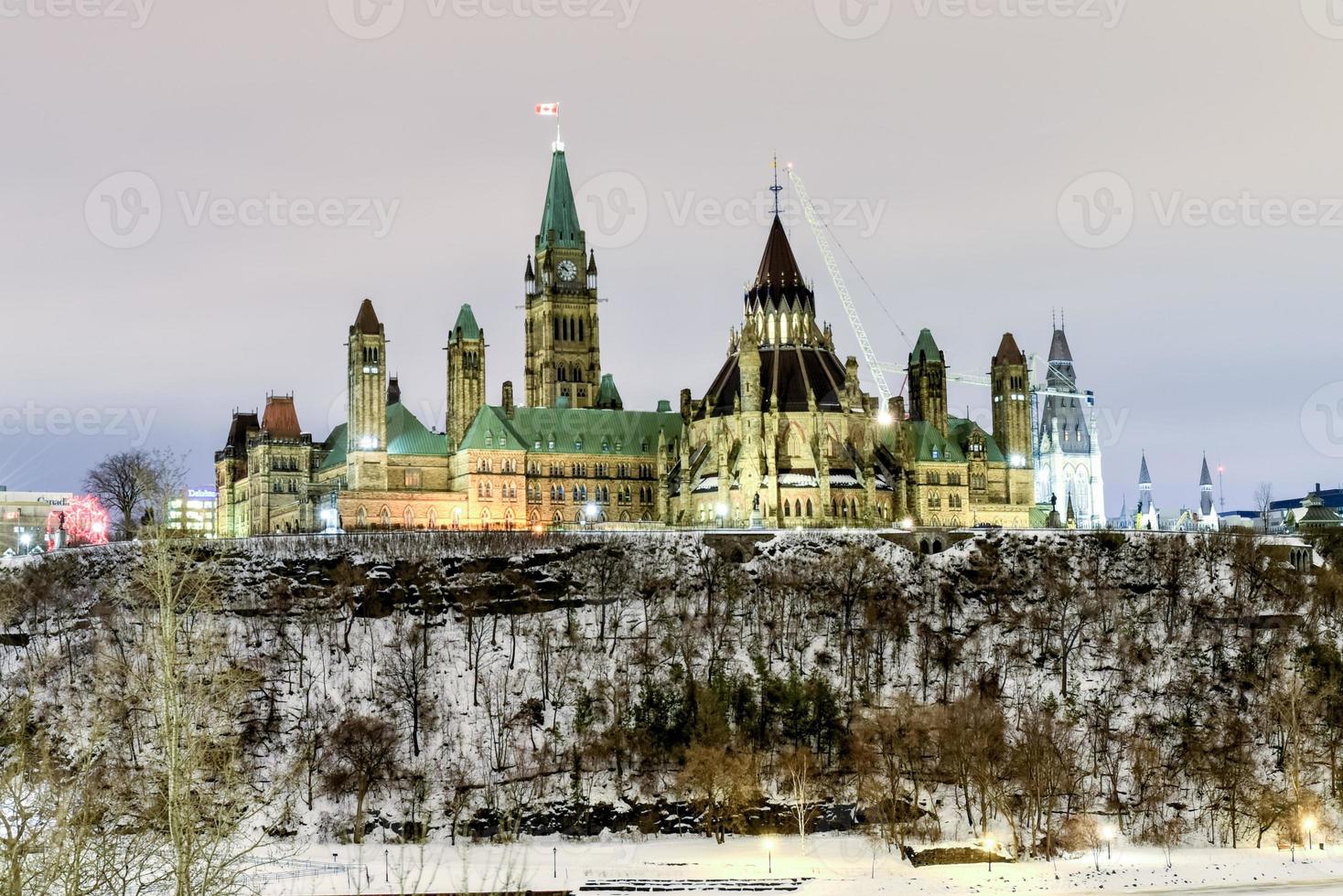 colina del parlamento y la casa del parlamento canadiense en ottawa, canadá durante el invierno por la noche. foto