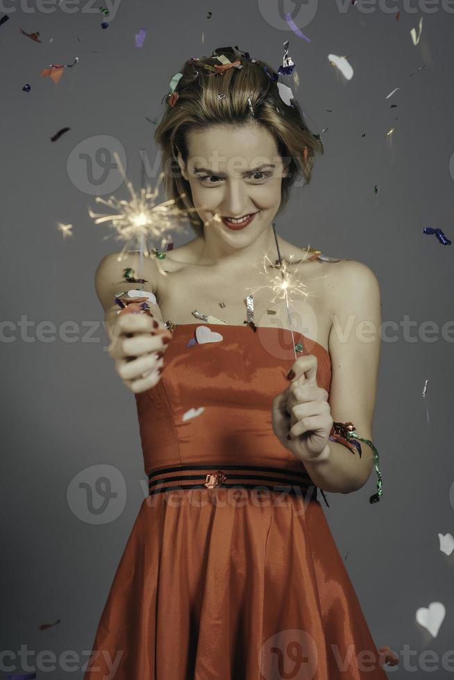 celebrando la fiesta de navidad o año nuevo con luces de bengala y champán rosa. foto