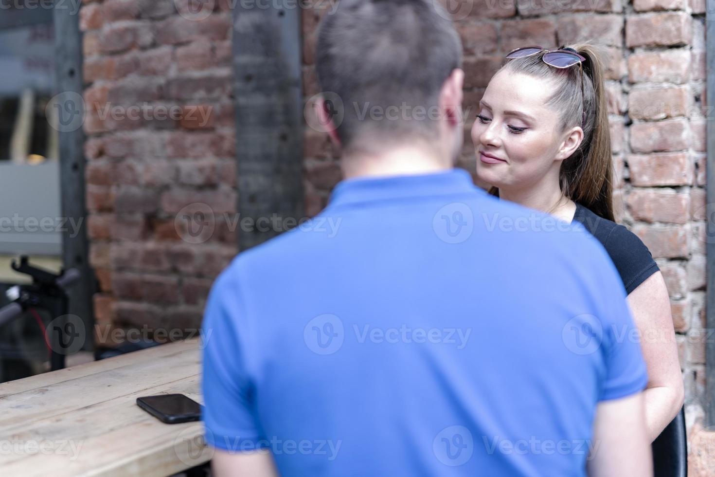 cheerful friends laughing enjoying having fun sitting together at restaurant table photo