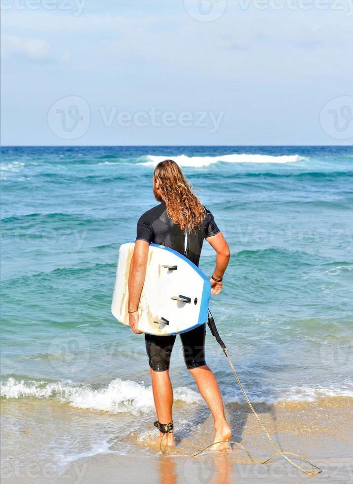 handsome surfer man on the beach photo