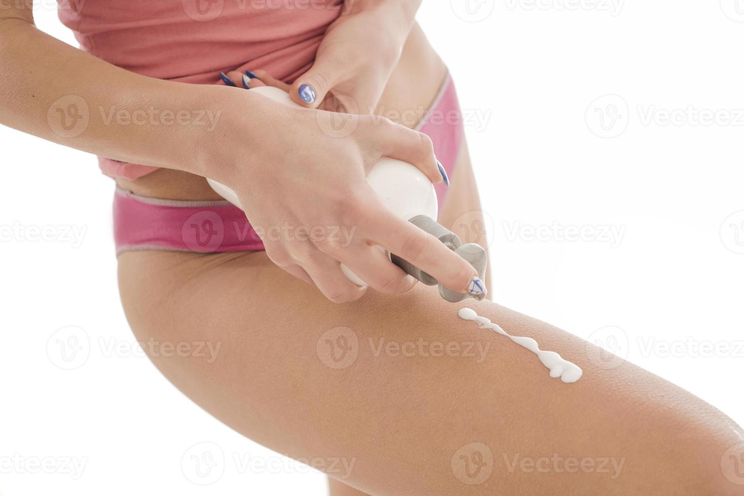 Body care. Woman applying cream on legs. Female applying anti cellulite cream photo