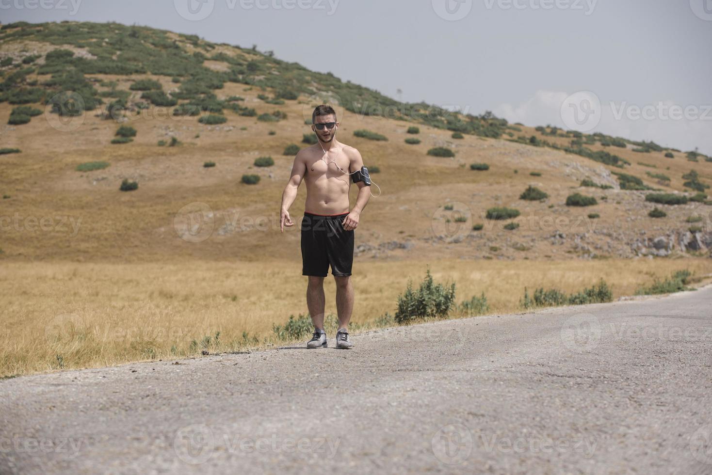 Young man runner running on a mountain road. Jogger training workout in fitness shoe. Healthy lifestyle and sport concept.  Motion blur and selective focus. photo