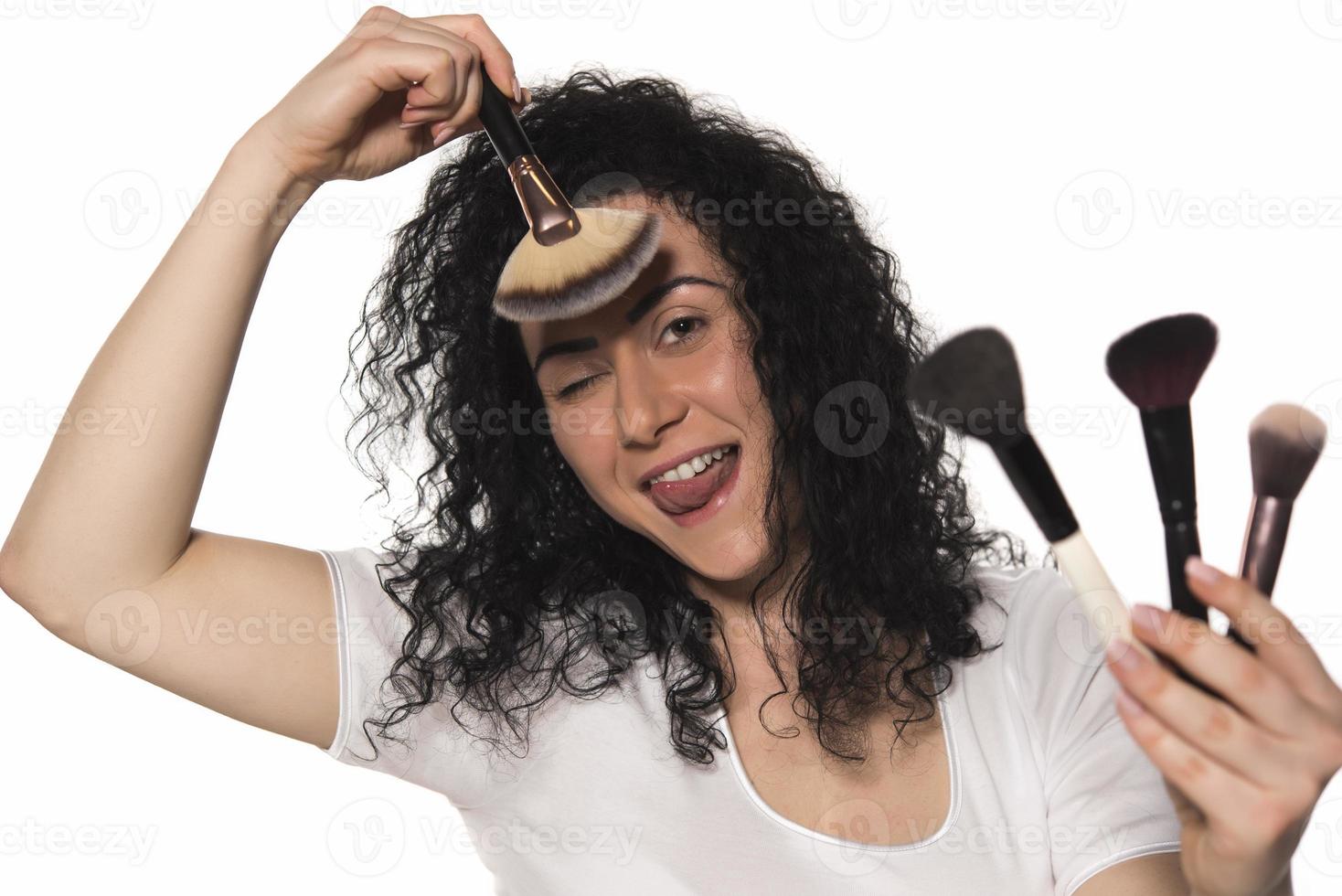 portrait of attractive caucasian smiling woman isolated on white studio shot putting make up in front of mirror photo