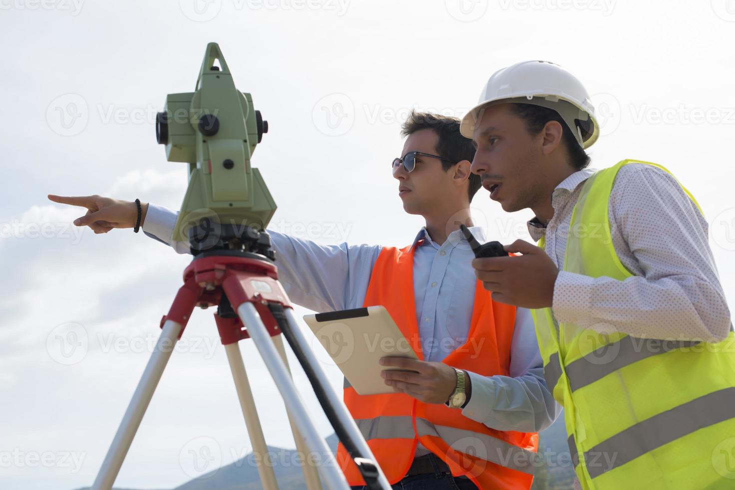 el ingeniero topógrafo está midiendo el nivel en el sitio de construcción. los topógrafos aseguran mediciones precisas antes de emprender grandes proyectos de construcción. foto