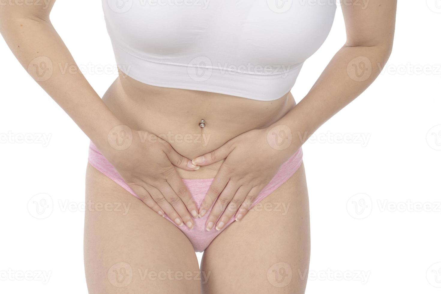 Young woman holding hands on belly at home. Gynecology photo