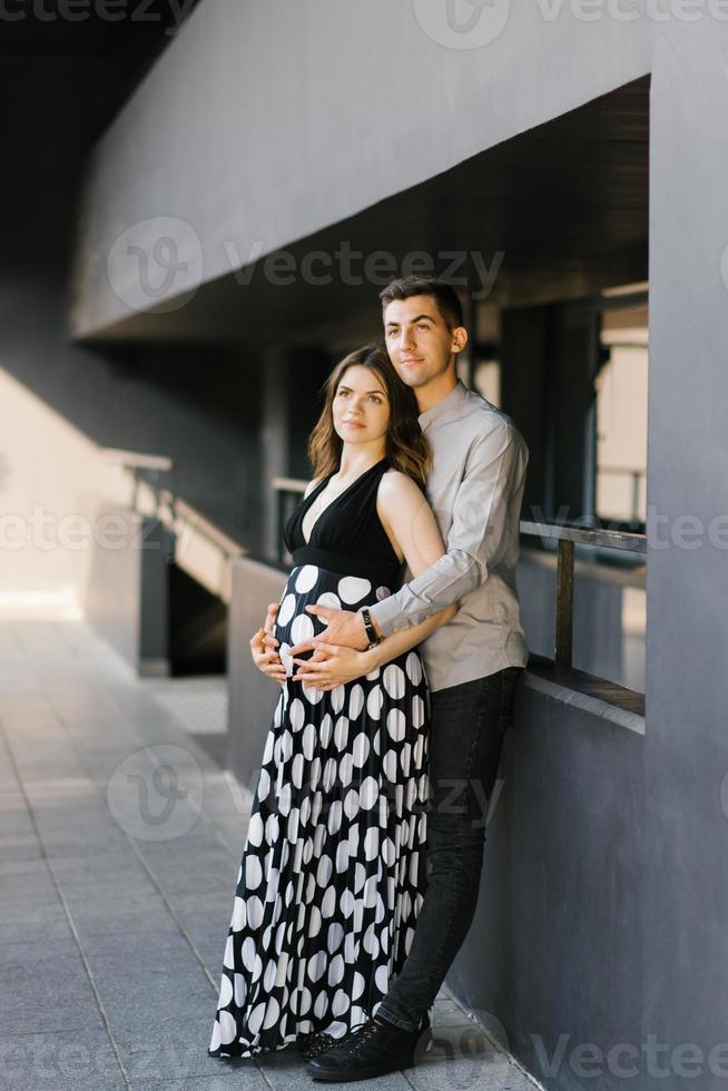una joven pareja esperando a su hijo. el esposo abraza el estómago de su esposa. primer embarazo. foto