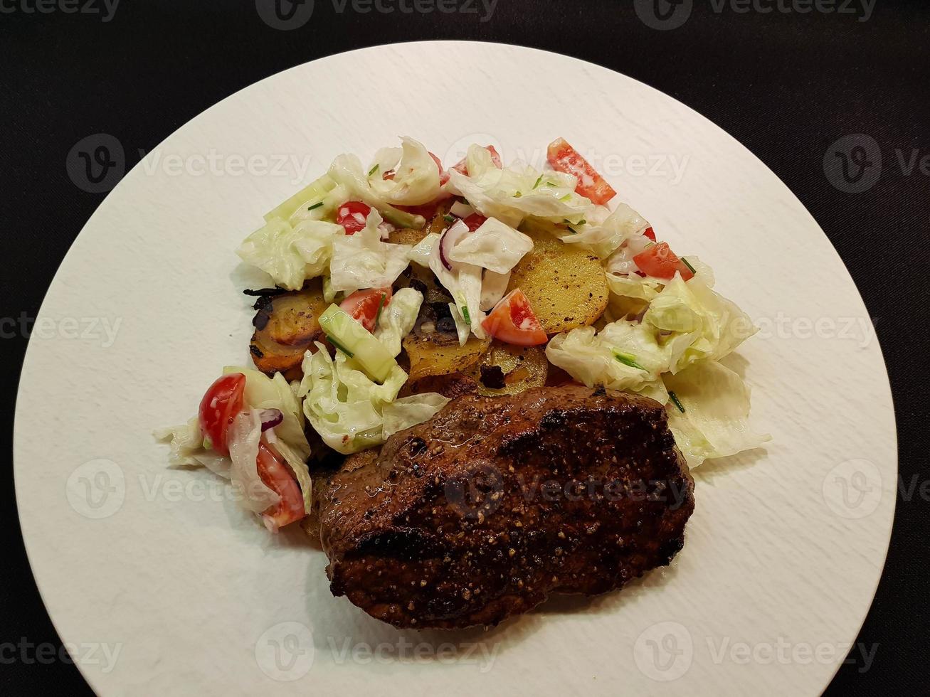 a freshly fried beef steak from the frying pan with delicious ingredients photo