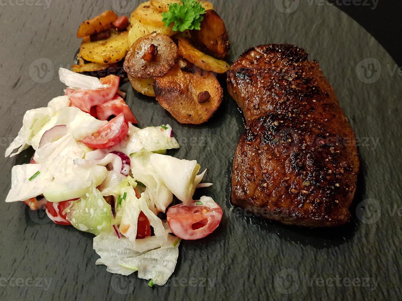 un bistec de ternera recién frito de la sartén con deliciosos ingredientes foto