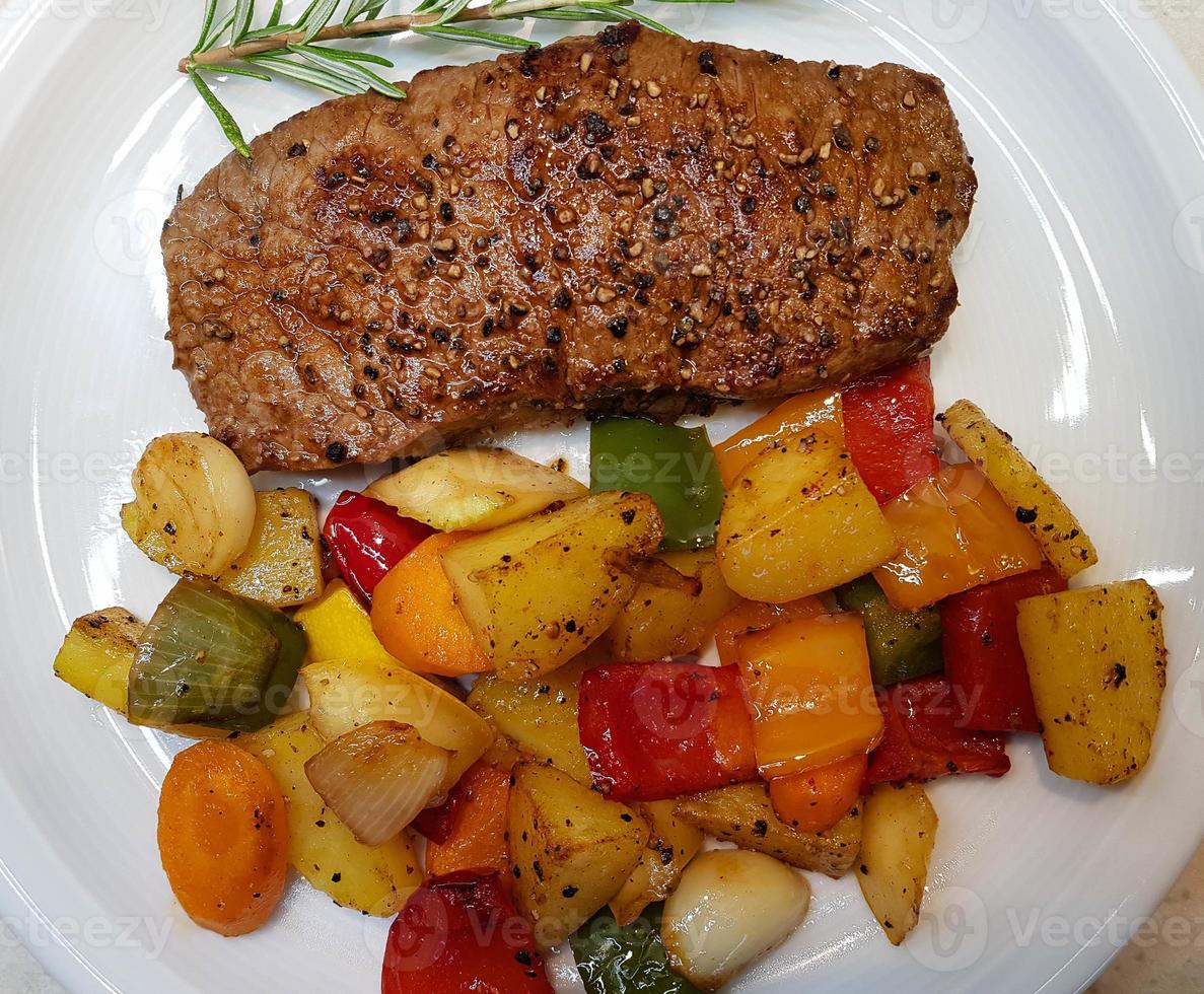 a freshly fried beef steak from the frying pan with delicious ingredients photo