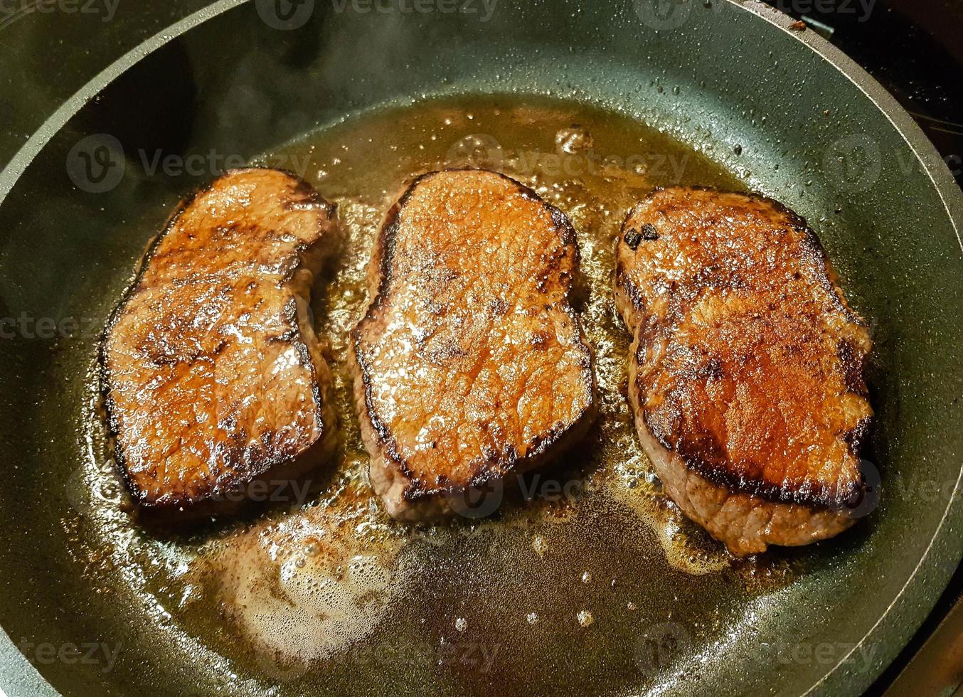 a freshly fried beef steak from the frying pan with delicious ingredients photo