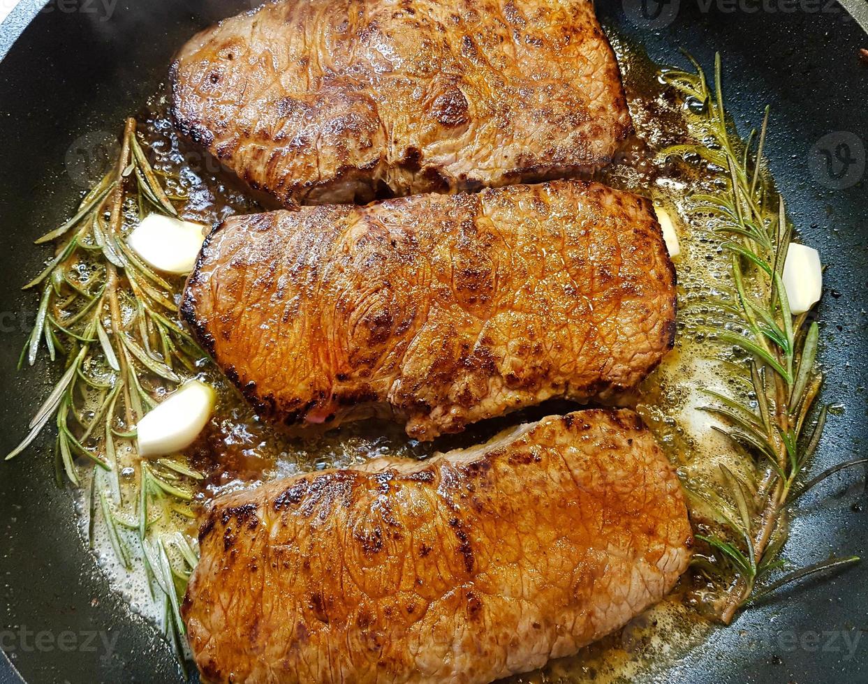 a freshly fried beef steak from the frying pan with delicious ingredients photo