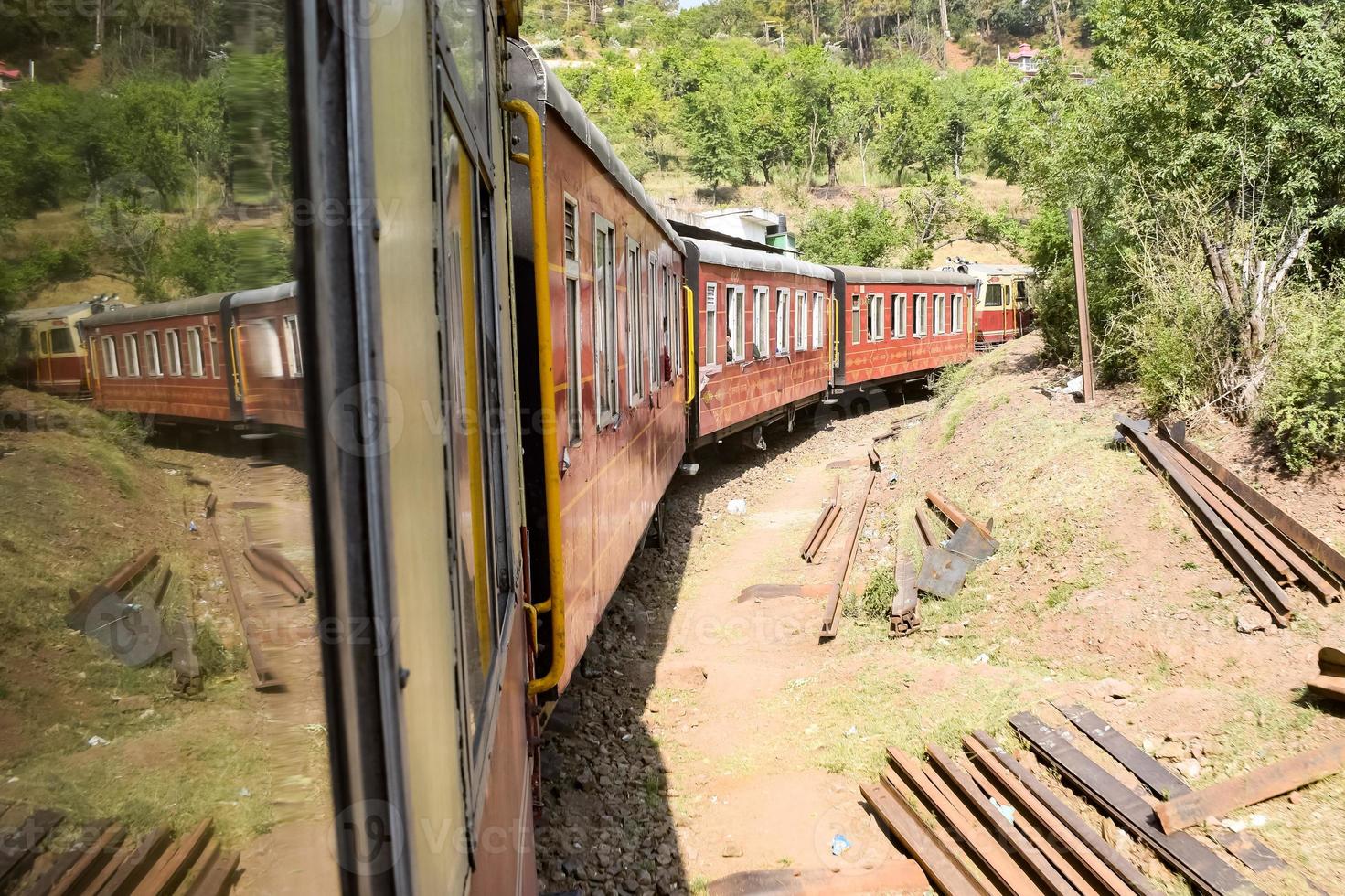 Toy Train moving on mountain slopes, beautiful view, one side mountain, one side valley moving on railway to the hill, among green natural forest. Toy train from Kalka to Shimla in India, Indian Train photo