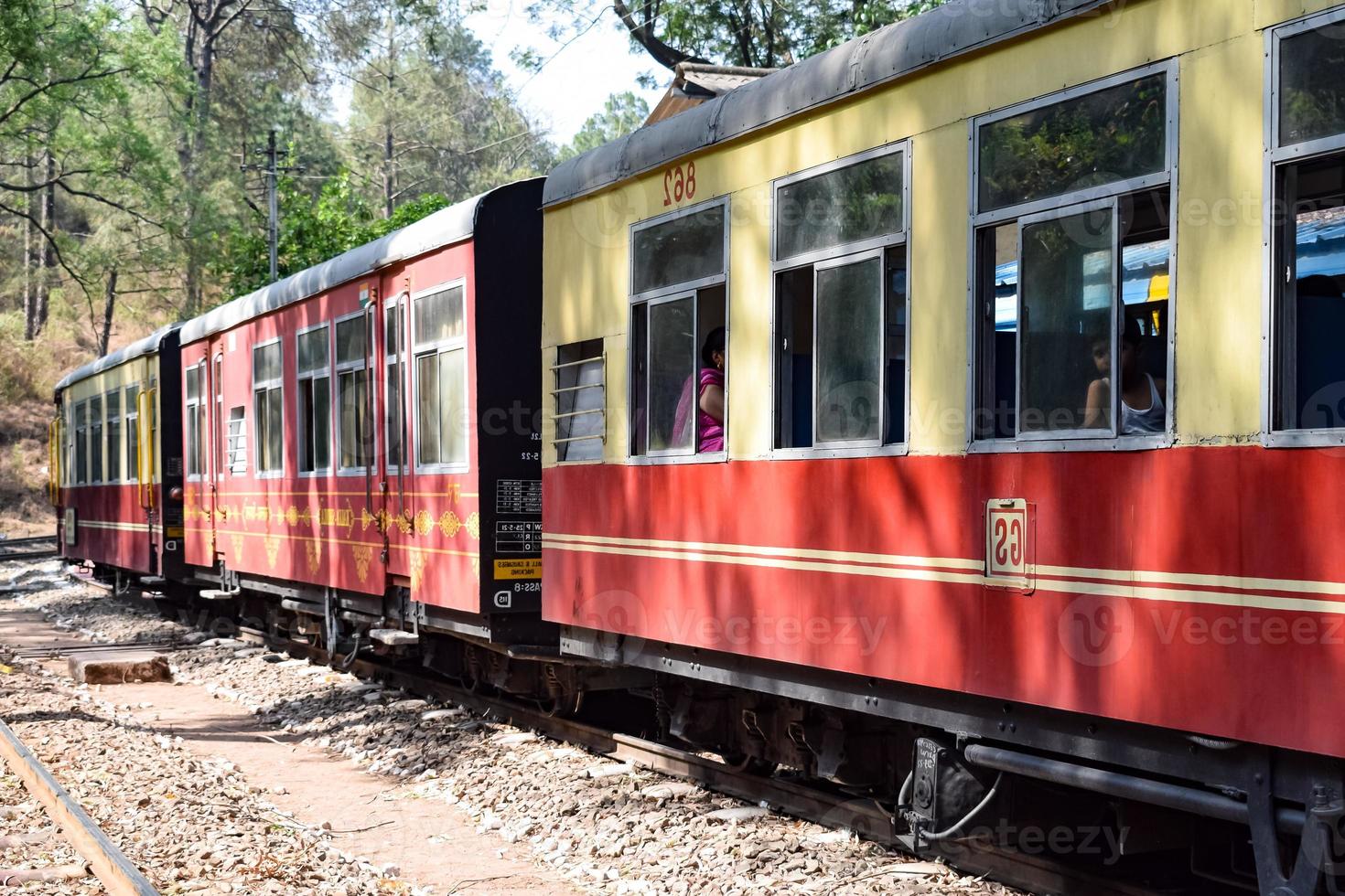 Toy Train moving on mountain slopes, beautiful view, one side mountain, one side valley moving on railway to the hill, among green natural forest. Toy train from Kalka to Shimla in India, Indian Train photo