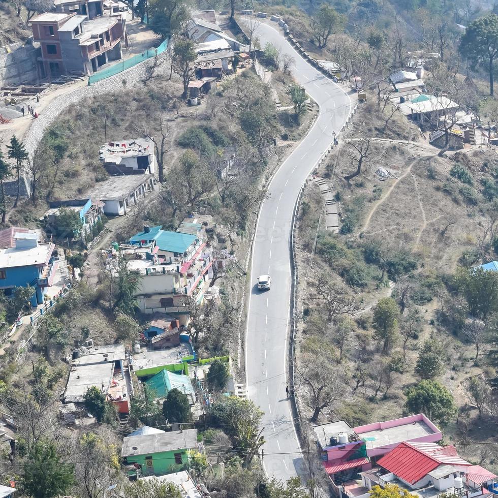 Aerial top view of traffic vehicles driving at mountains roads at Nainital, Uttarakhand, India, View from the top side of mountain for movement of traffic vehicles photo