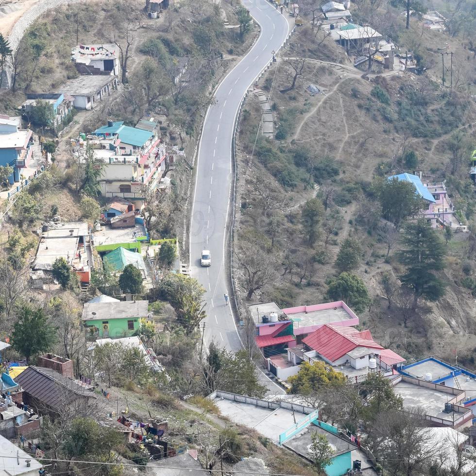 Aerial top view of traffic vehicles driving at mountains roads at Nainital, Uttarakhand, India, View from the top side of mountain for movement of traffic vehicles photo