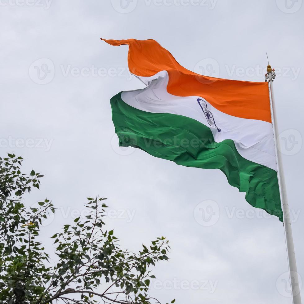 India flag flying high at Connaught Place with pride in blue sky, India flag fluttering, Indian Flag on Independence Day and Republic Day of India, tilt up shot, Waving Indian flag, Har Ghar Tiranga photo