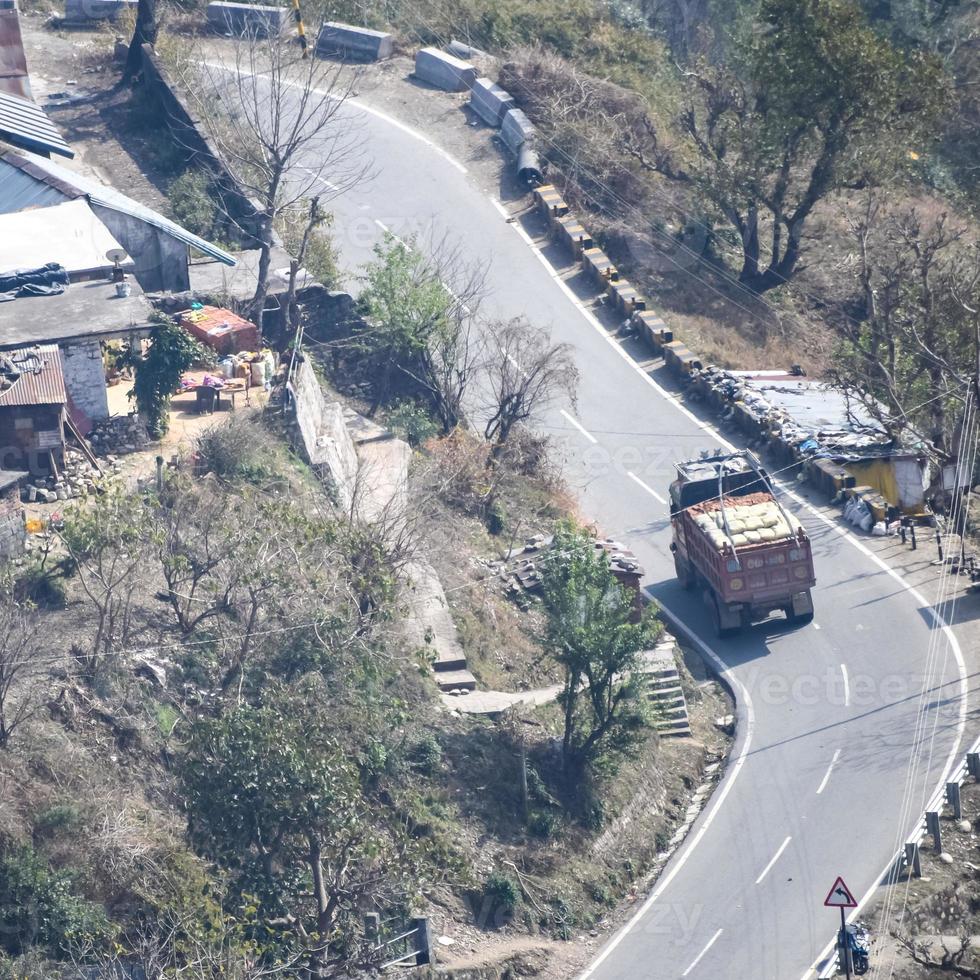 Aerial top view of traffic vehicles driving at mountains roads at Nainital, Uttarakhand, India, View from the top side of mountain for movement of traffic vehicles photo