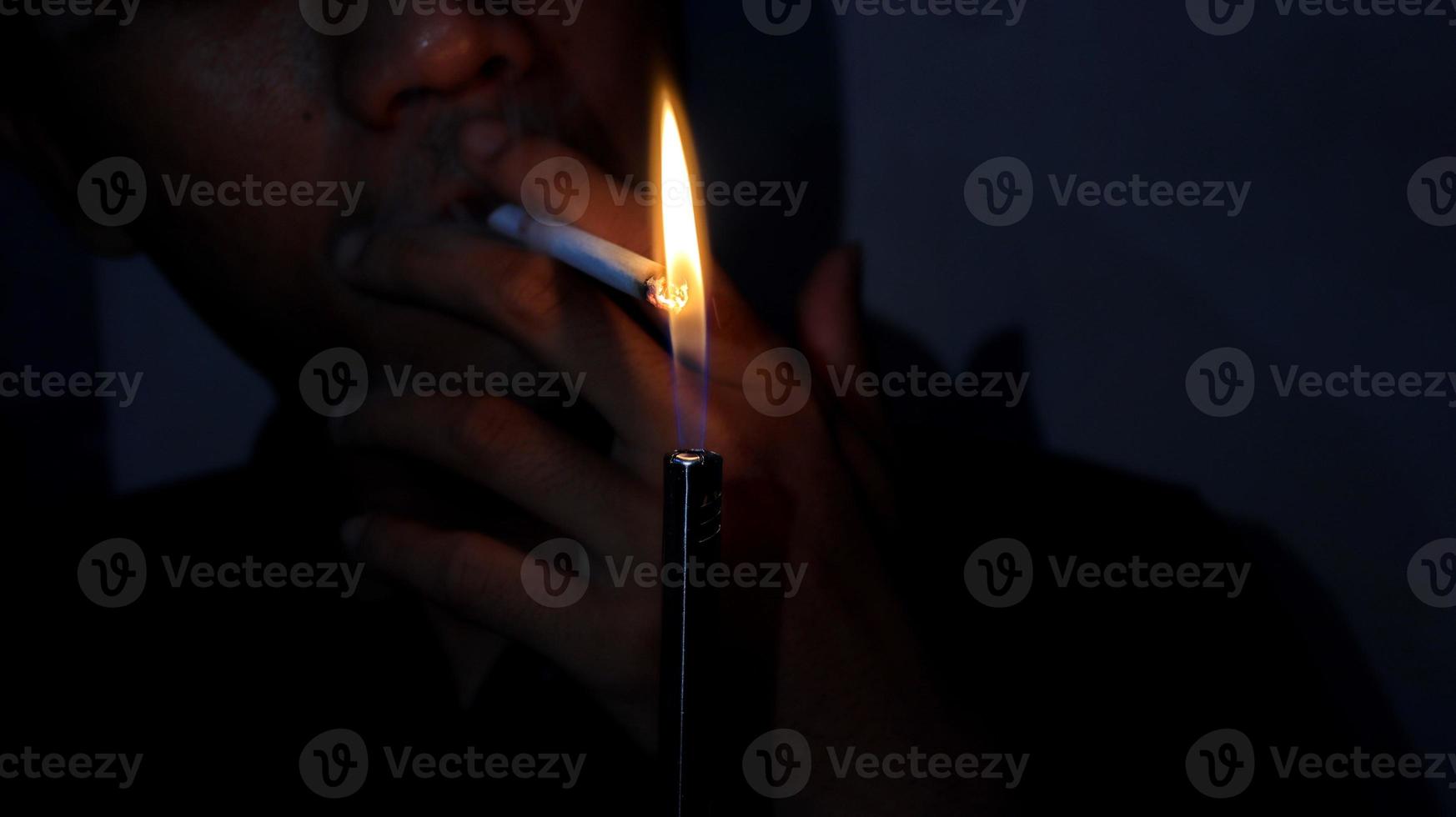 fumador encendiendo un cigarrillo con un encendedor de gas. foto
