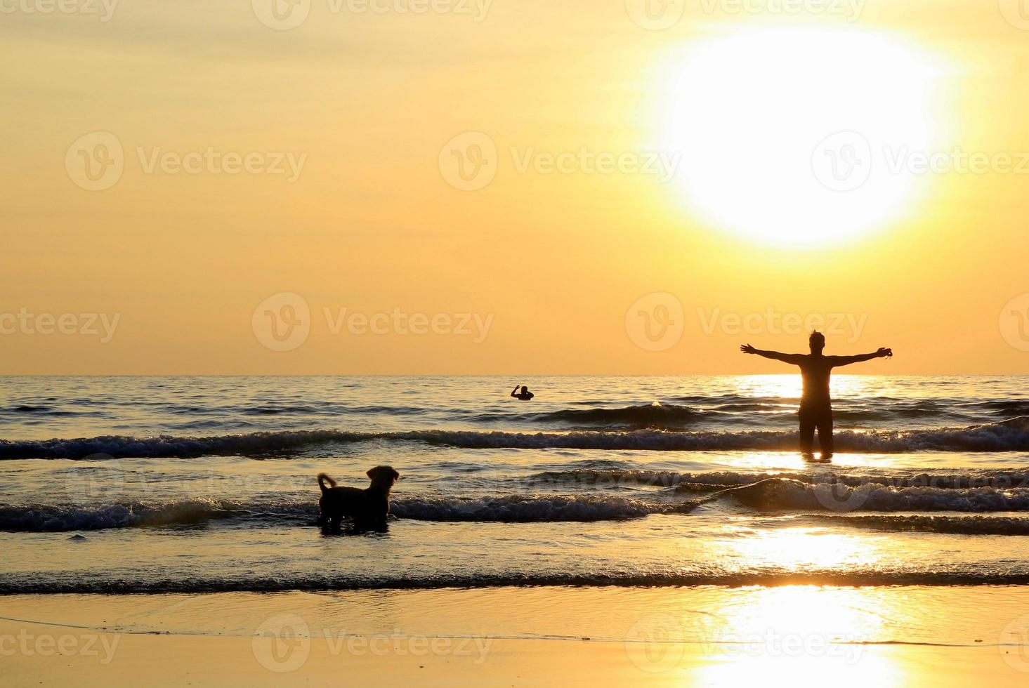 Travel to island Koh Chang, Thailand. A man with a dog are walking on the sunset beach. photo