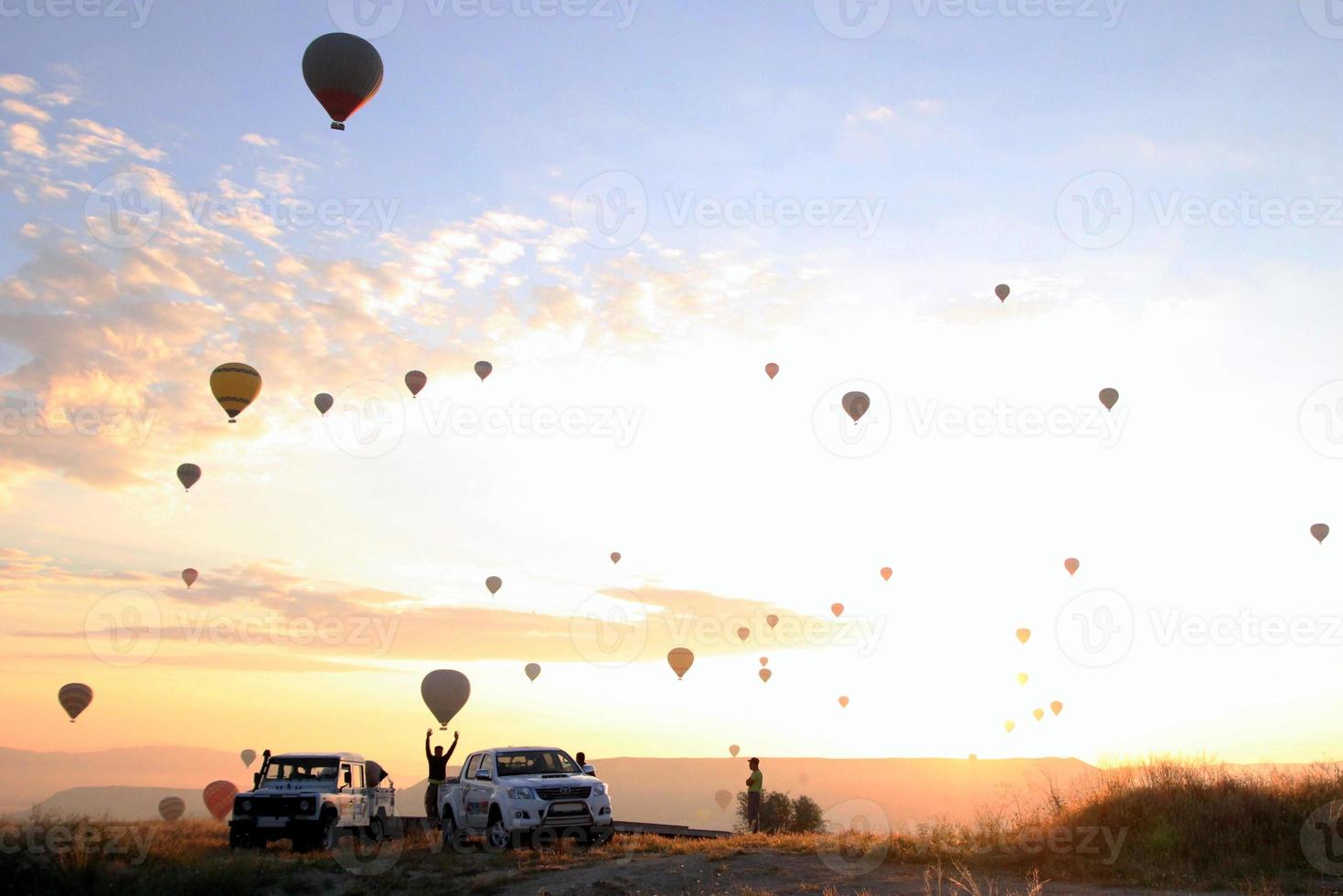 viajar a goreme, capadocia, turquía. el amanecer en las montañas con mucho aire globos calientes en el cielo. foto