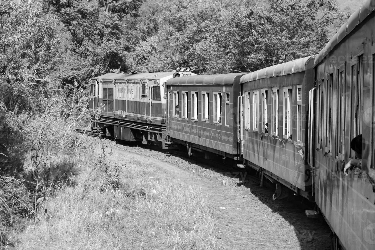 Toy Train moving on mountain slope, beautiful view, one side mountain, one side valley moving on railway to the hill, among green natural forest.Toy train from Kalka to Shimla in India-Black and White photo
