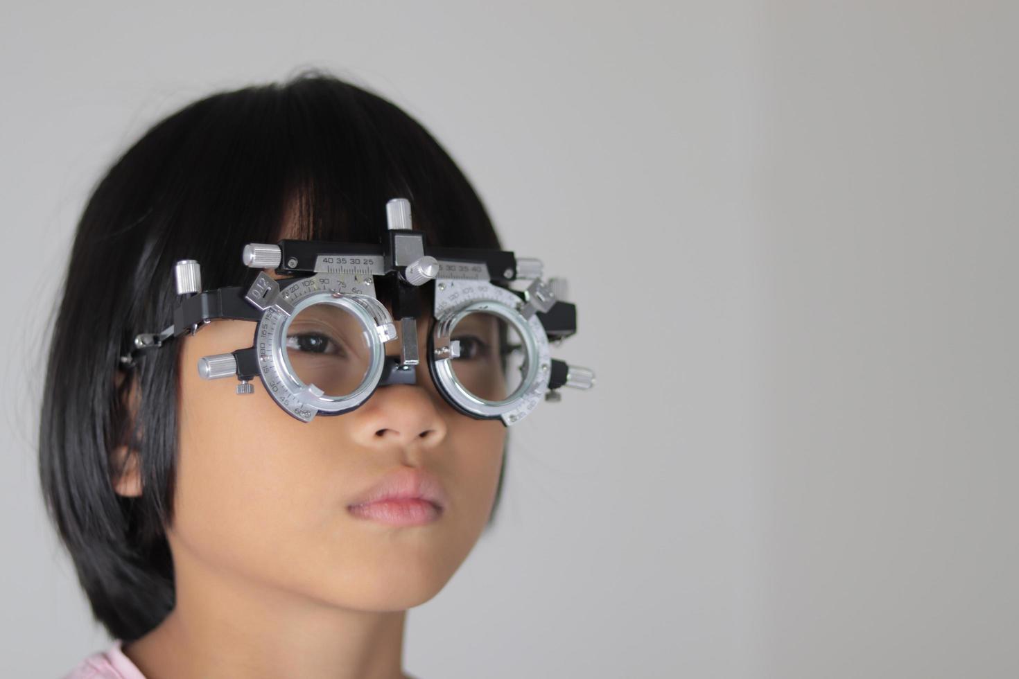 Girl wearing trial frame eyeglasses, eye test concept photo