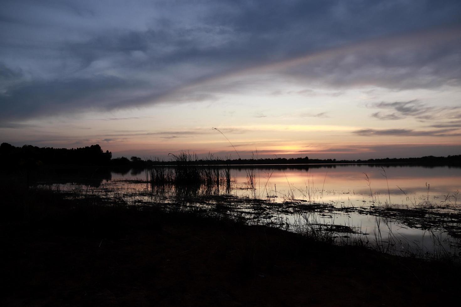 hermosa vista de la naturaleza al atardecer, vista del cielo rojo-naranja y río al atardecer. foto