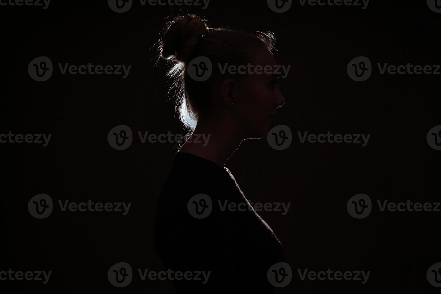 profle view of woman hiding in the dark photo