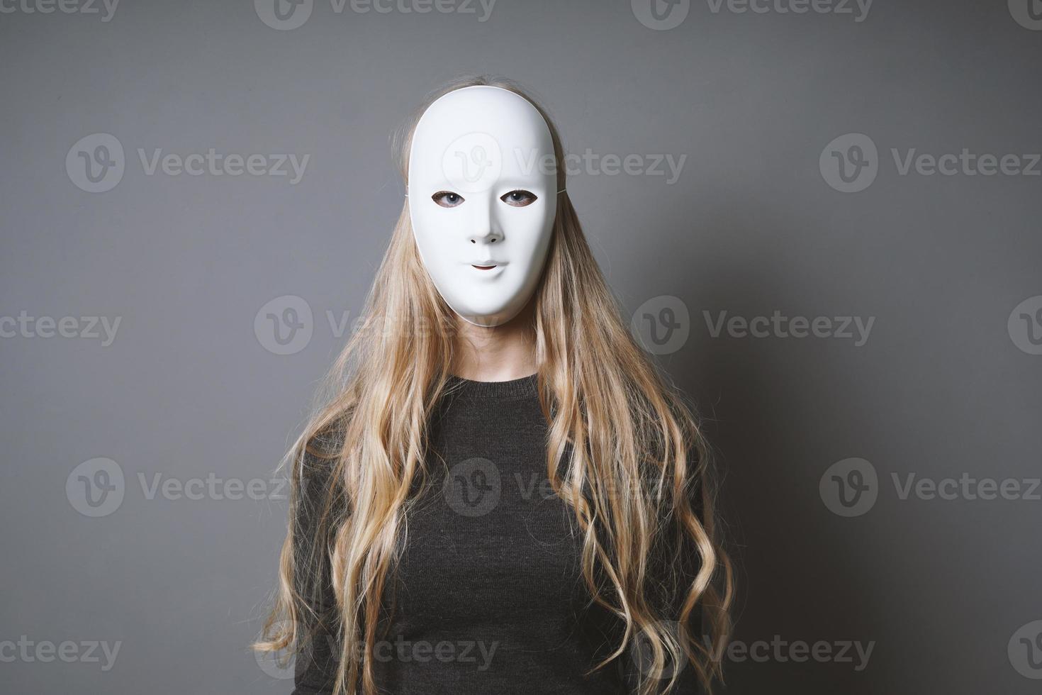 mysterious woman hiding face and identity behind mask photo