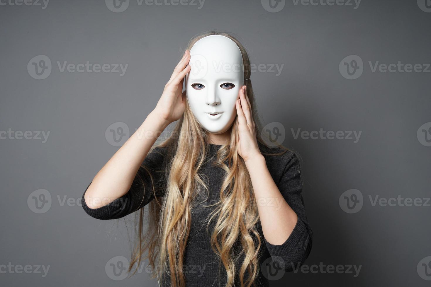 mysterious young woman adjusting her mask photo