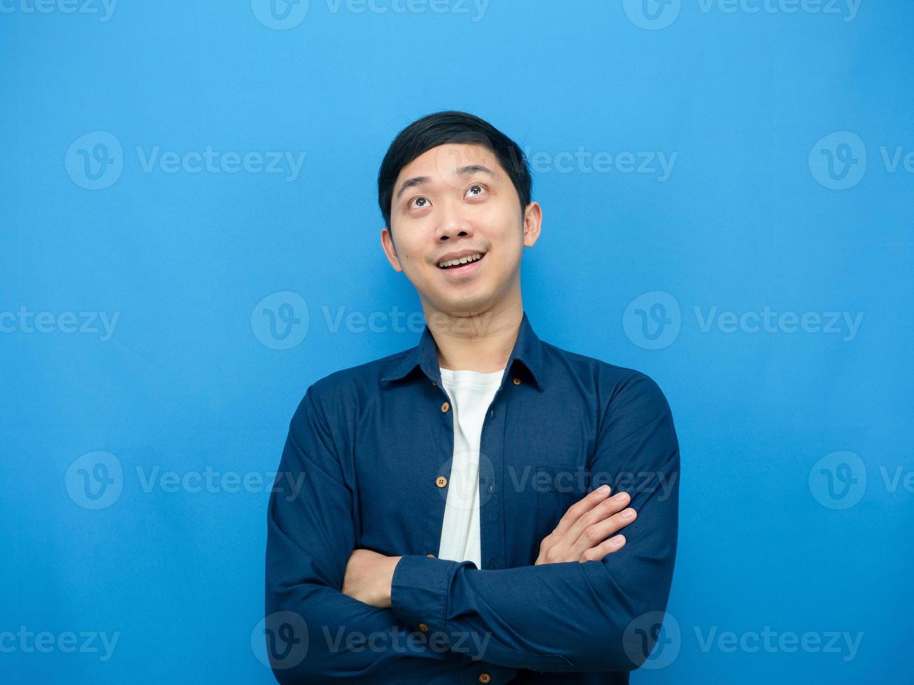 Asian man cross arm cheerful and looking up copy space photo