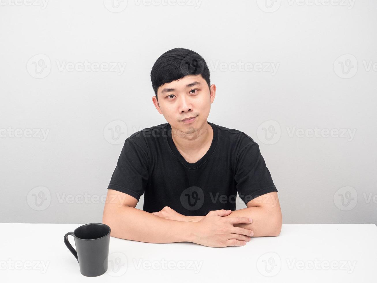 hombre guapo sentarse a la mesa con una taza de café confiado foto