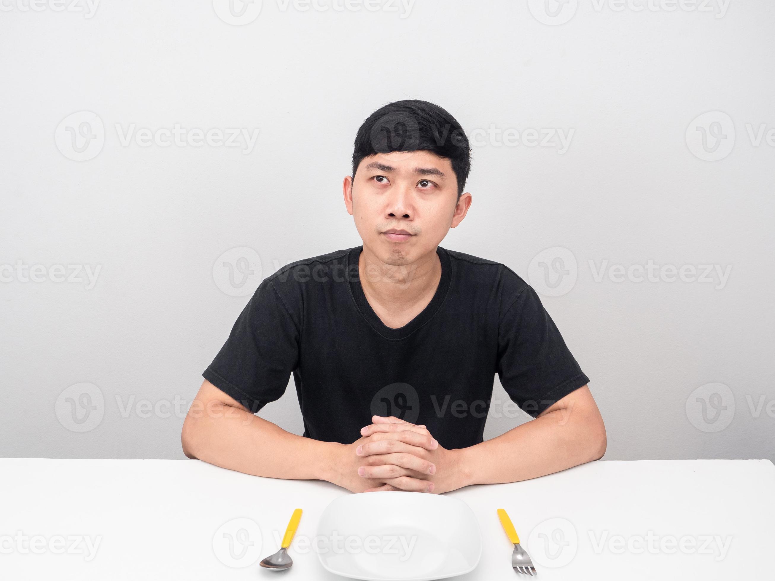 Asian man sit at table thinking about food 16684370 Stock Photo at Vecteezy