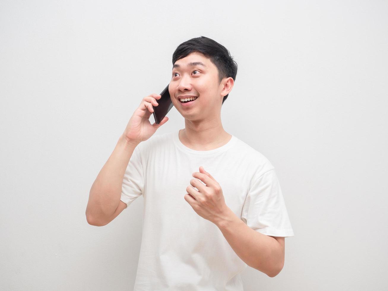 hombre asiático escuchando buenas noticias con cara feliz de teléfono de llamada sobre fondo blanco foto