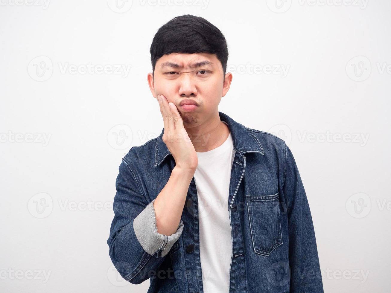hombre asiático camisa de mezclilla sintiendo dolor de muelas tocar su mejilla foto